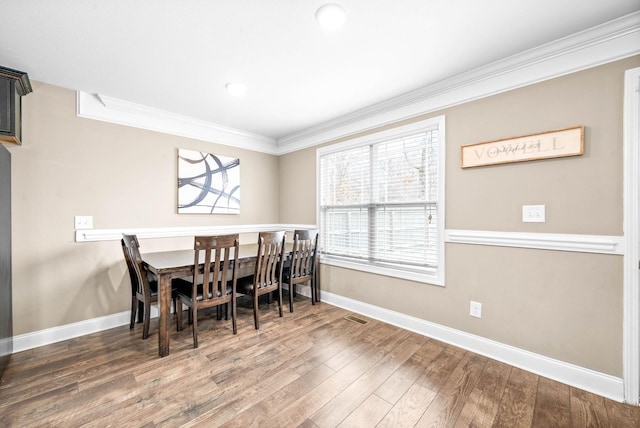 dining area featuring dark hardwood / wood-style floors and ornamental molding