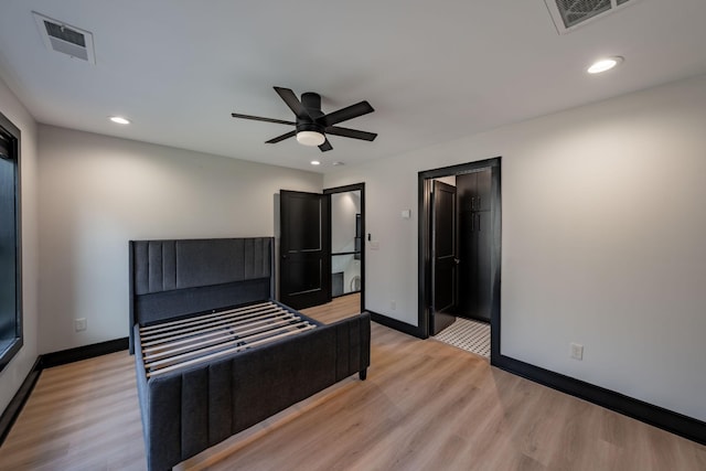 unfurnished bedroom featuring ceiling fan, a spacious closet, a closet, and light wood-type flooring