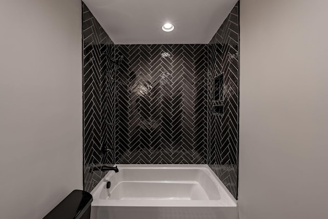 bathroom with tile walls, toilet, and shower / bathtub combination