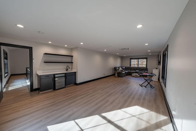 workout area featuring sink, beverage cooler, and light hardwood / wood-style flooring