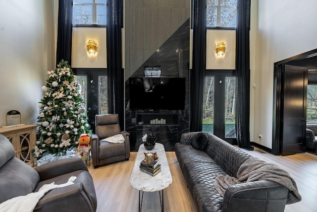 living room featuring a high ceiling and light hardwood / wood-style floors