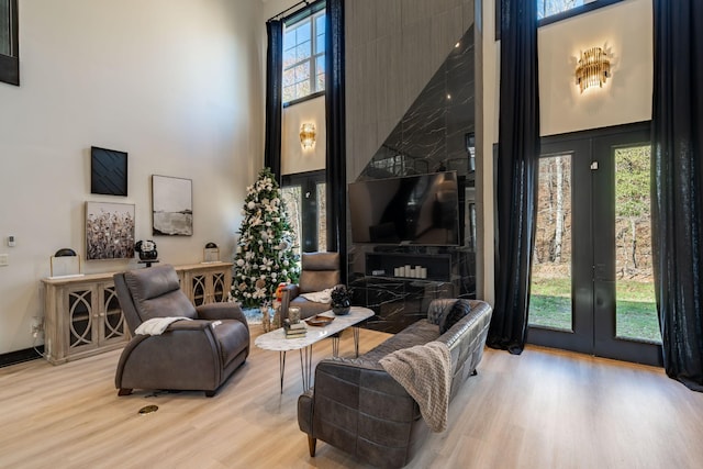 living room featuring a high ceiling and light wood-type flooring