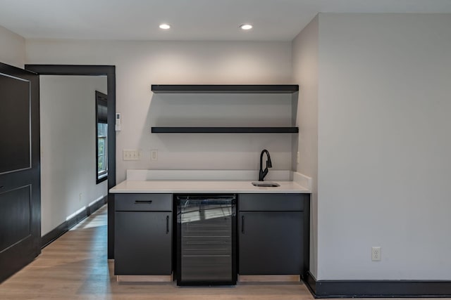 kitchen with sink, beverage cooler, and light hardwood / wood-style flooring