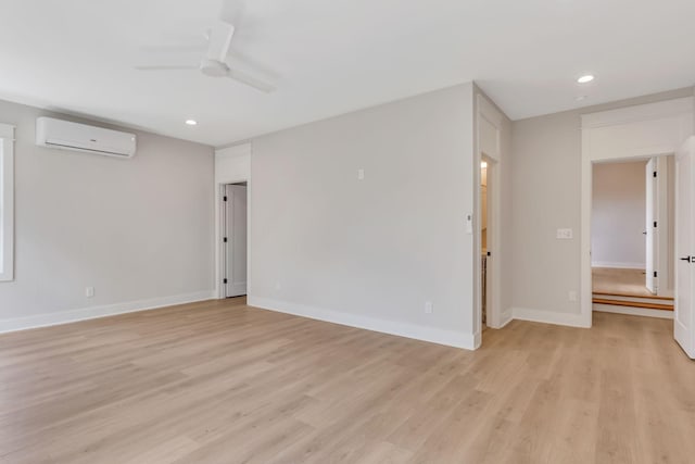 empty room featuring baseboards, a wall unit AC, recessed lighting, light wood-style floors, and a ceiling fan