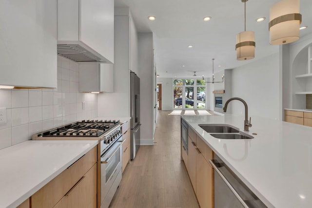 kitchen featuring white cabinetry, light brown cabinets, sink, decorative light fixtures, and appliances with stainless steel finishes