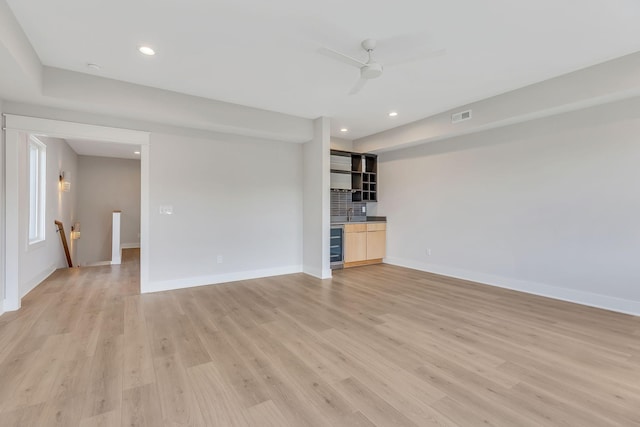 unfurnished living room with light wood-type flooring, visible vents, baseboards, and recessed lighting