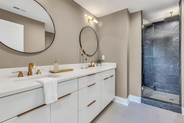 full bath with a marble finish shower, visible vents, baseboards, double vanity, and a sink