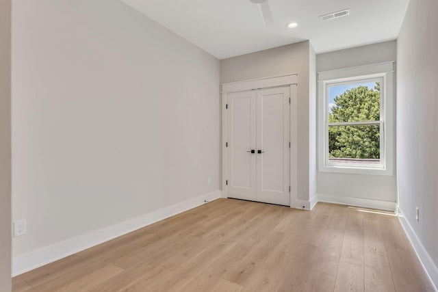 unfurnished bedroom featuring ceiling fan, light wood-type flooring, and a closet