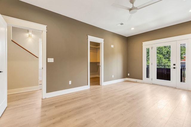 spare room featuring visible vents, ceiling fan, light wood-type flooring, and baseboards