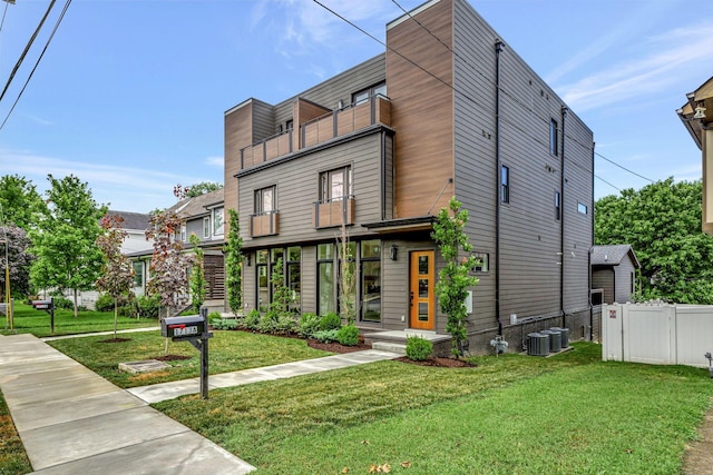 contemporary house featuring central AC unit and a front yard