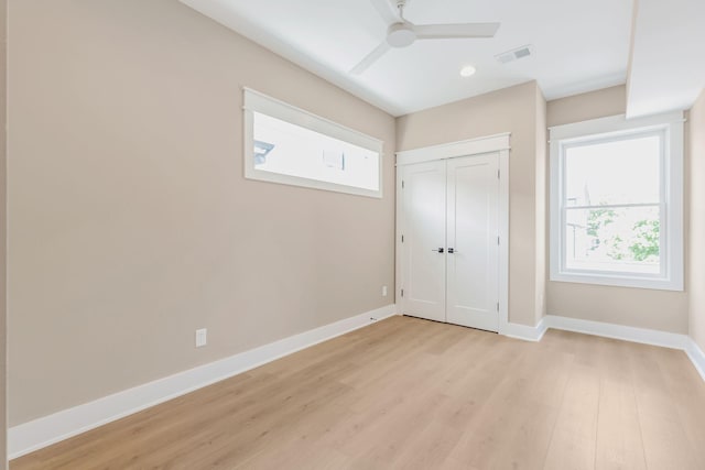 unfurnished bedroom featuring a closet, baseboards, visible vents, and light wood finished floors