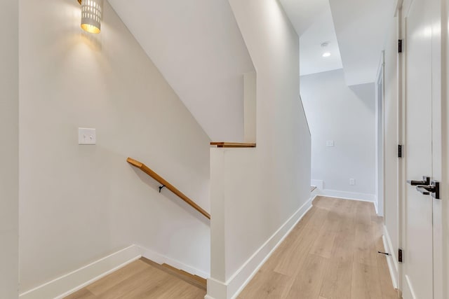 hall featuring recessed lighting, an upstairs landing, light wood-type flooring, and baseboards