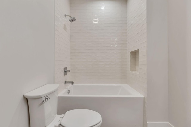 bathroom featuring tiled shower / bath combo and toilet