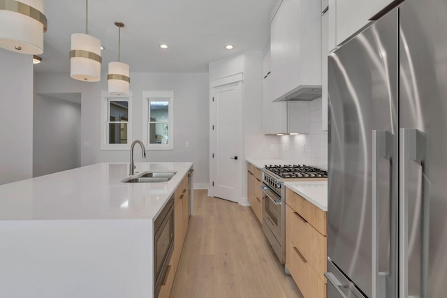 kitchen with white cabinetry, sink, an island with sink, custom range hood, and appliances with stainless steel finishes