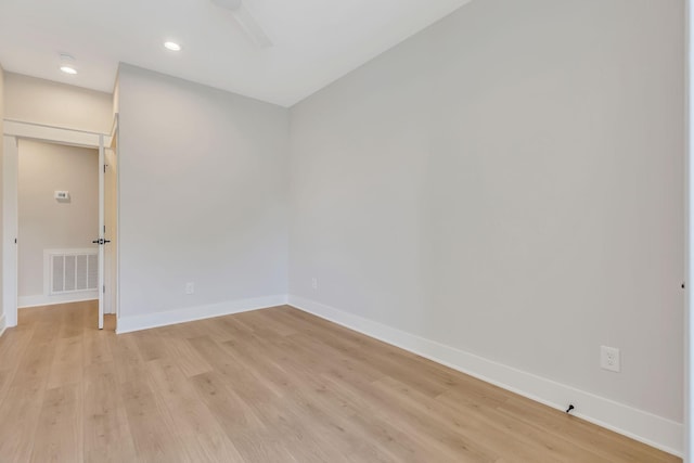 empty room featuring light wood-style floors, recessed lighting, baseboards, and visible vents