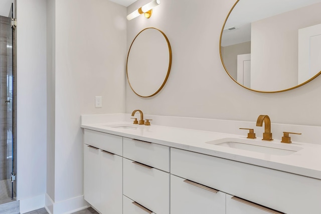 bathroom with double vanity, visible vents, baseboards, and a sink