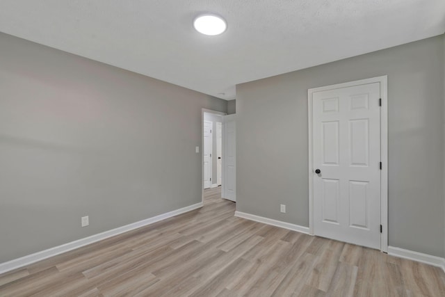 unfurnished bedroom with a textured ceiling and light wood-type flooring