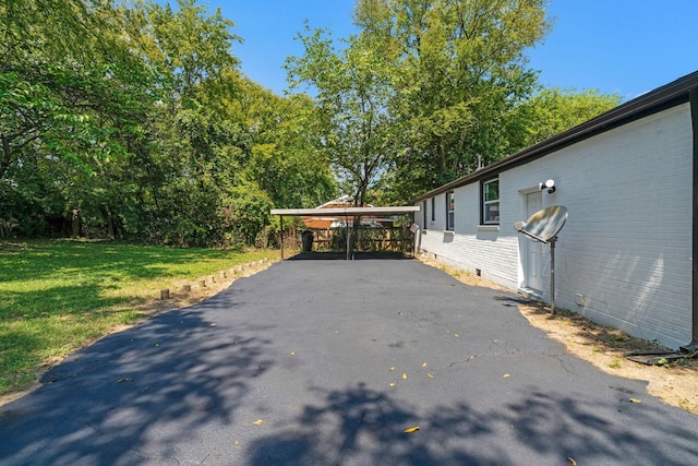 view of home's exterior featuring a carport and a yard