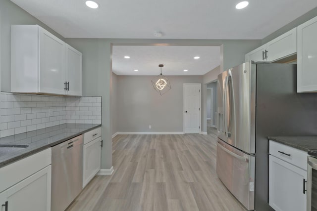 kitchen featuring white cabinetry, hanging light fixtures, tasteful backsplash, light hardwood / wood-style floors, and appliances with stainless steel finishes