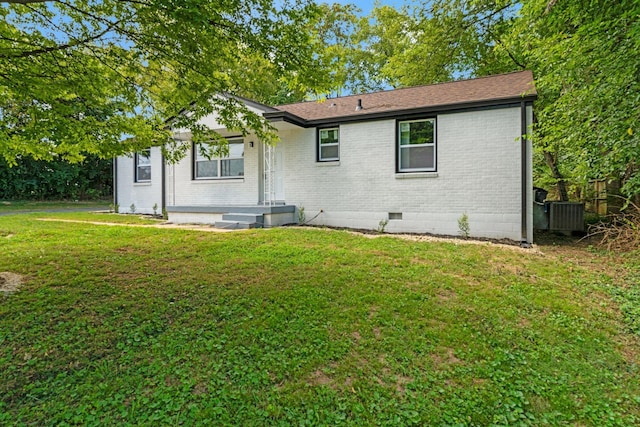 rear view of property featuring cooling unit and a yard