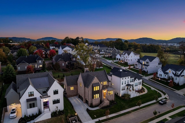 aerial view at dusk featuring a mountain view