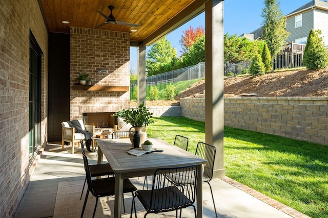 view of patio featuring an outdoor brick fireplace and ceiling fan