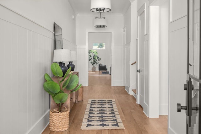 hall featuring light wood-type flooring and crown molding