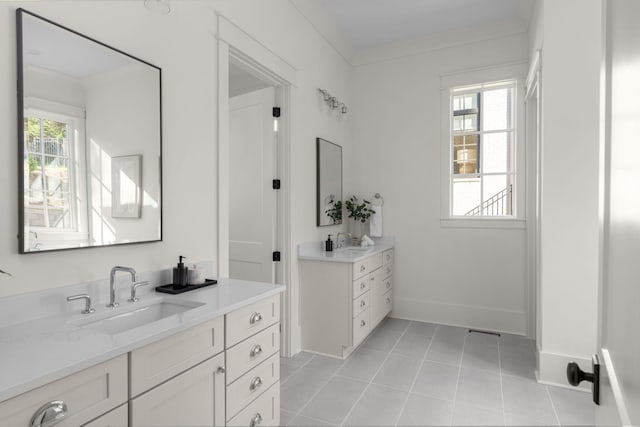 bathroom featuring tile patterned flooring, vanity, a healthy amount of sunlight, and ornamental molding