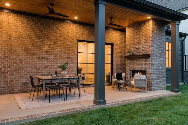 view of patio / terrace featuring an outdoor brick fireplace and ceiling fan