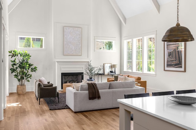 living room featuring beamed ceiling, light hardwood / wood-style floors, and high vaulted ceiling