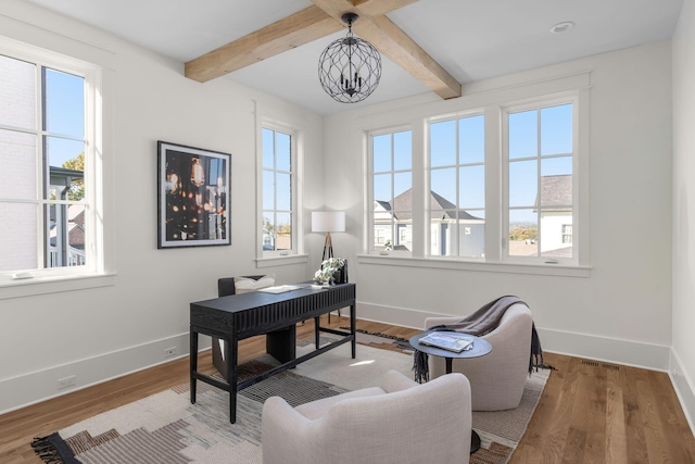 home office featuring beamed ceiling, a healthy amount of sunlight, hardwood / wood-style flooring, and an inviting chandelier