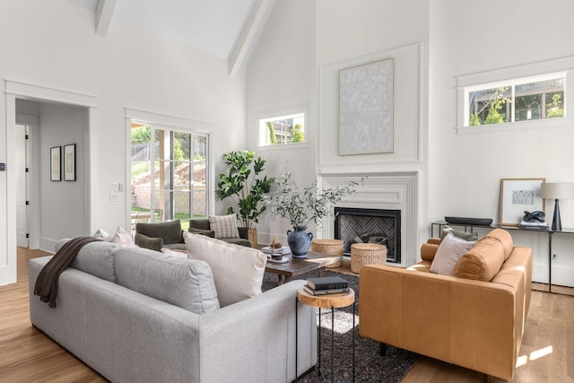 living room with beam ceiling, light hardwood / wood-style flooring, and high vaulted ceiling