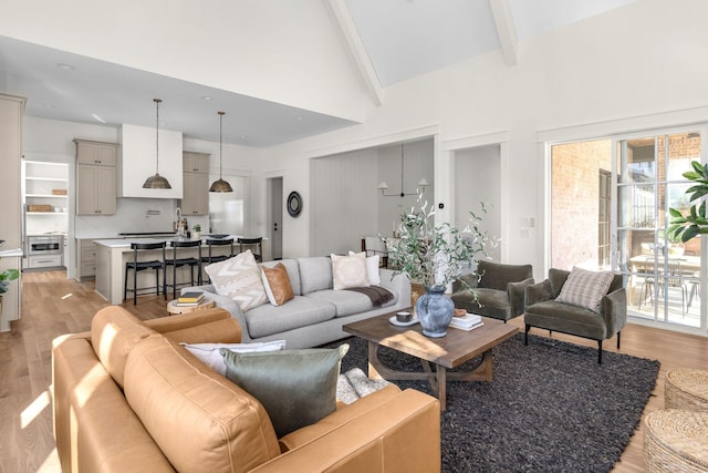 living room featuring light hardwood / wood-style flooring, beamed ceiling, and high vaulted ceiling