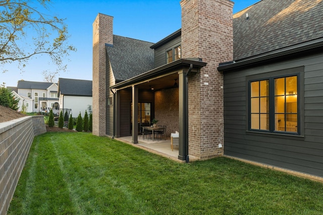 rear view of property featuring a lawn and a patio area