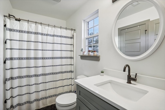 bathroom featuring vanity, toilet, and walk in shower