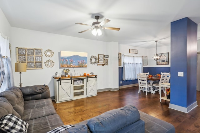 living room featuring ceiling fan and dark wood-type flooring