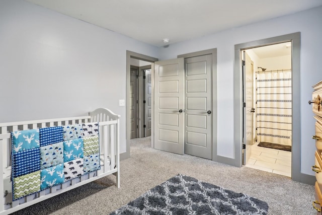 bedroom featuring ensuite bathroom and carpet floors