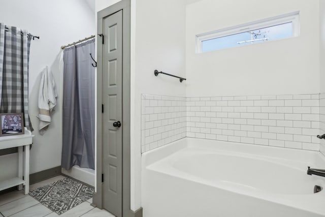 bathroom with tile patterned floors and a washtub