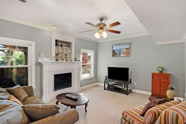 living room with a wealth of natural light, crown molding, ceiling fan, and light colored carpet