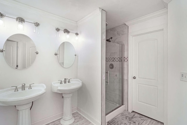 bathroom featuring a shower with door, dual sinks, and ornamental molding