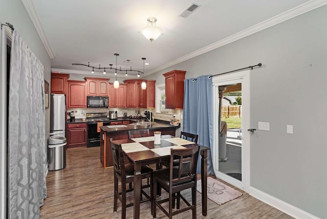 dining room with dark hardwood / wood-style floors, ornamental molding, and sink