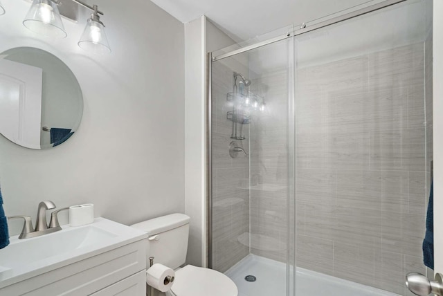 bathroom with vanity, toilet, and a shower with shower door