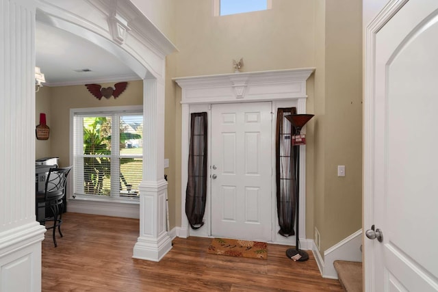 foyer entrance with dark hardwood / wood-style floors and crown molding