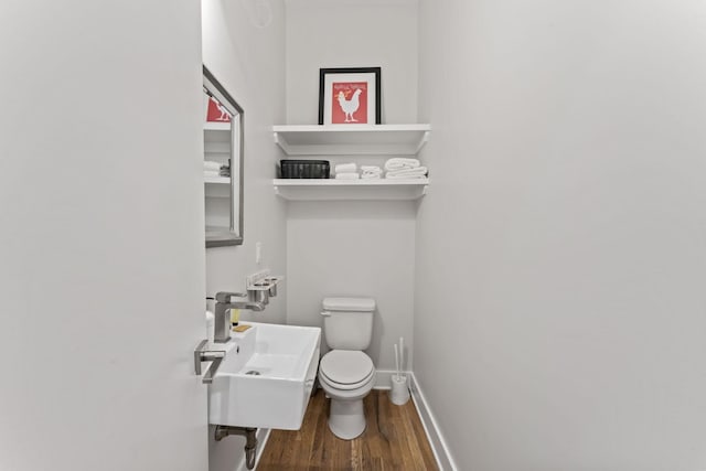 bathroom featuring hardwood / wood-style flooring, toilet, and sink