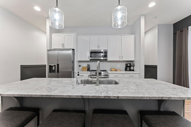 kitchen featuring white cabinetry, pendant lighting, stainless steel appliances, and sink