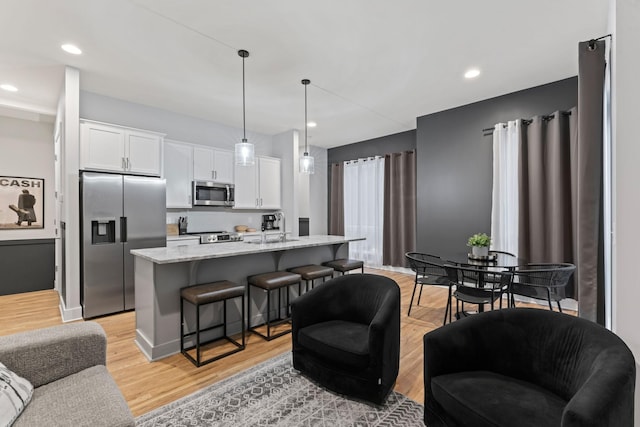 living room with sink and light wood-type flooring