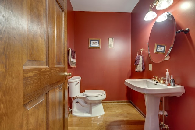 bathroom with toilet and hardwood / wood-style floors