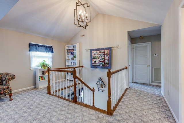 hallway with lofted ceiling, carpet flooring, and a chandelier