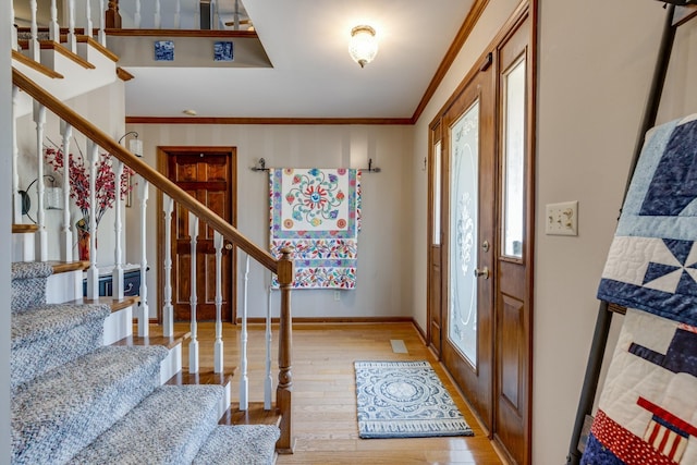 foyer featuring ornamental molding and light hardwood / wood-style flooring