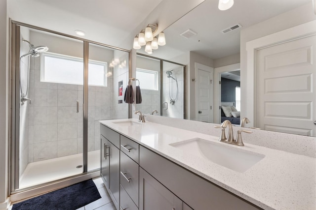 bathroom with tile patterned floors, vanity, and a shower with shower door